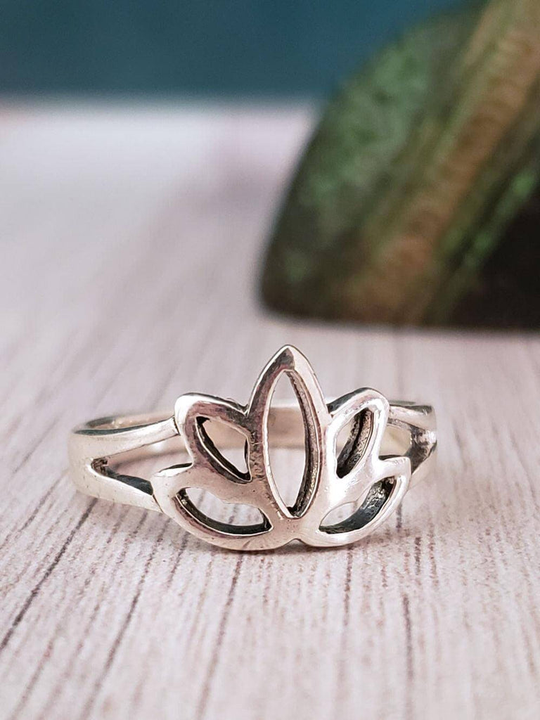 Premium Photo | A silver lotus ring with diamonds on a wooden surface.